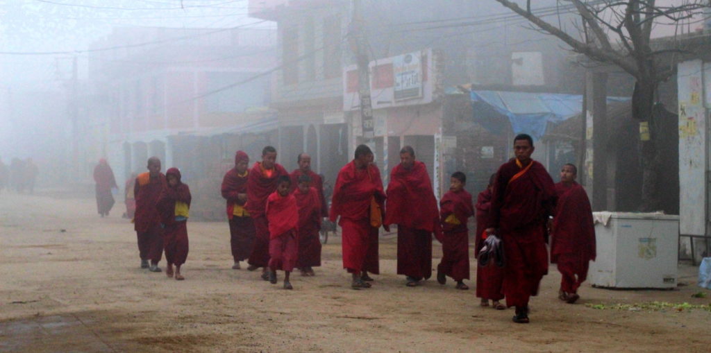 Moines avançant dans la brume à Lumbini, Népal