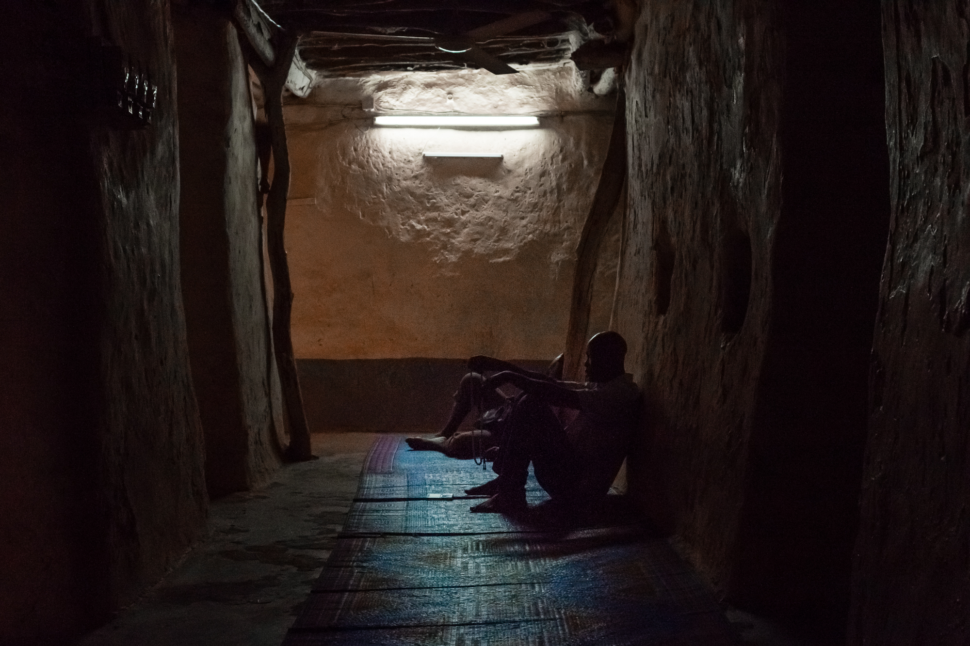 Hommes priant dans l'intérieur sombre de la Grande Mosquée de Bobo Dioulasso, Burkina Faso