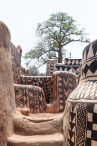 Cases décorées de la cour royale de Tiébélé et arbre au loin, Burkina Faso