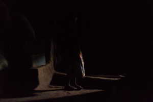 Silhouette dans la pénombre d'une case du village Lobi de Sansana, Burkina Faso