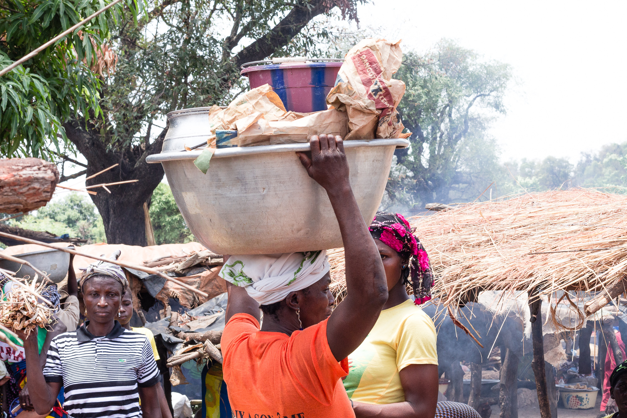 Femme portant une bassine remplie sur sa tête, marché de Doudou, pays Lobi, Burkina Faso