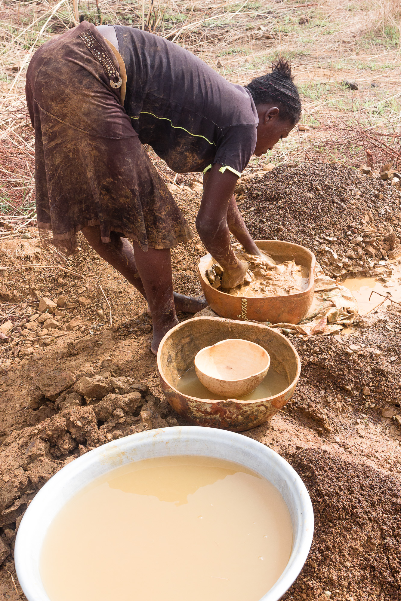Chercheuse d'or lavant la terre du pays Lobi, Burkina Faso