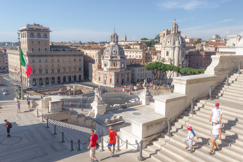Vue sur la Piazza Venezia depuis les escaliers du monument à Victor-Emmanuel II, et famille de touristes aux couleurs de l'Italie, Rome
