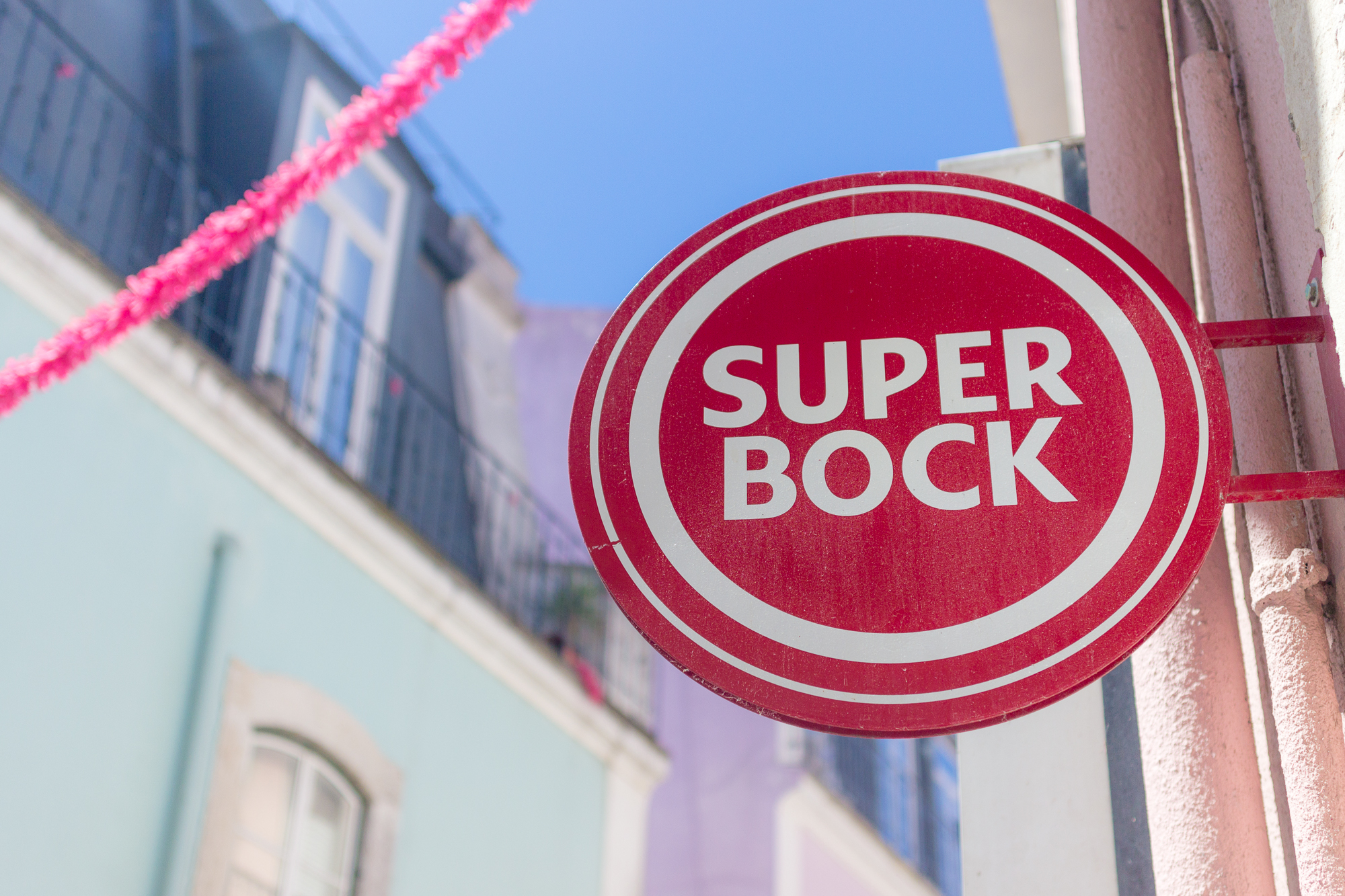 Panneau Super Bock, guirlande et façades pastels, Alfama, Lisbonne, Portugal