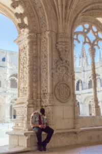 Un gardien du monastère des Hiéronymites assis à l'ombre du cloître, les yeux sur son téléphone, Belém, Lisbonne, Portugal