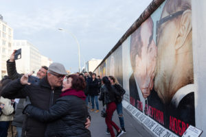 Touristes s'embrassant devant la fresque le baiser de l'amitié