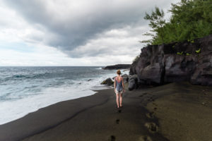 Marcheuse sur plage de sable noir, sud sauvage, réunion